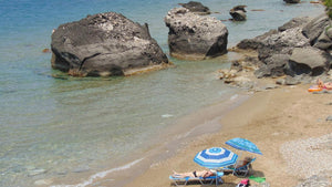 Small group of beginners practicing gentle yoga on mats overlooking the sea